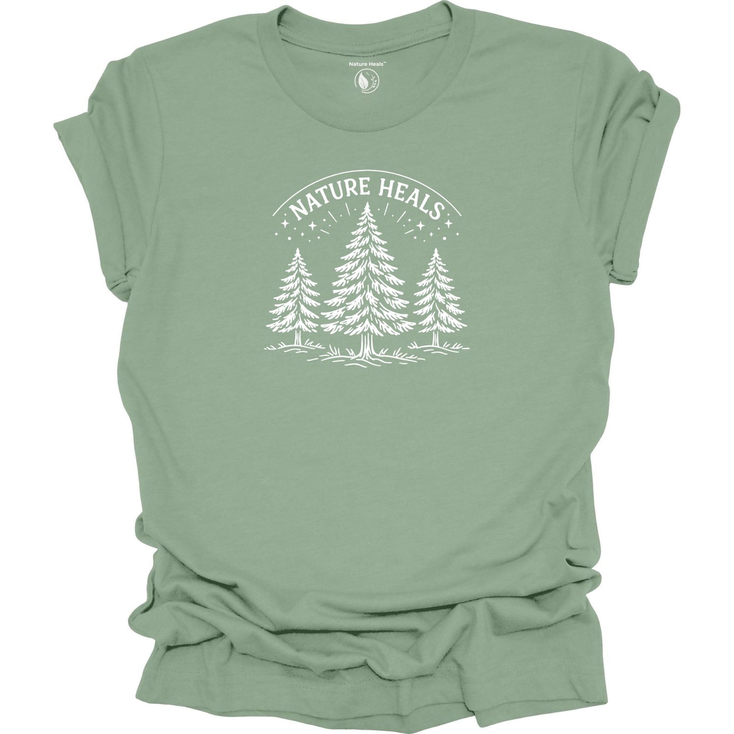 Minimalist Nature Heals t-shirt with pine tree graphic on soft sage green fabric, designed for nature lovers, wellness, and outdoor lifestyle