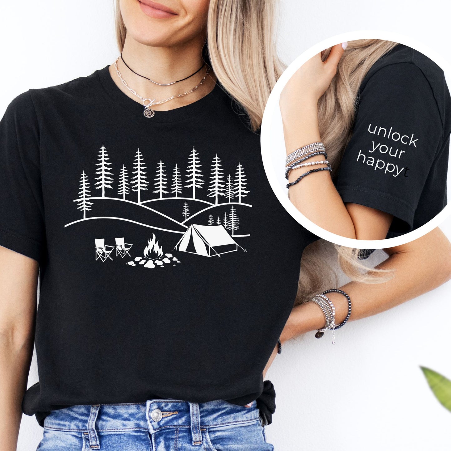 Close up of black camping inspired t-shirt sleeve featuring “unlock your happy” text detail