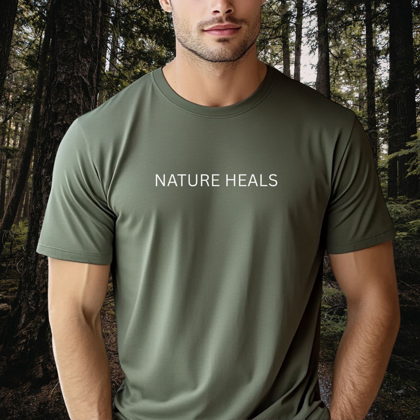 Man wearing a green t-shirt with 'NATURE HEALS' text in a forest setting
