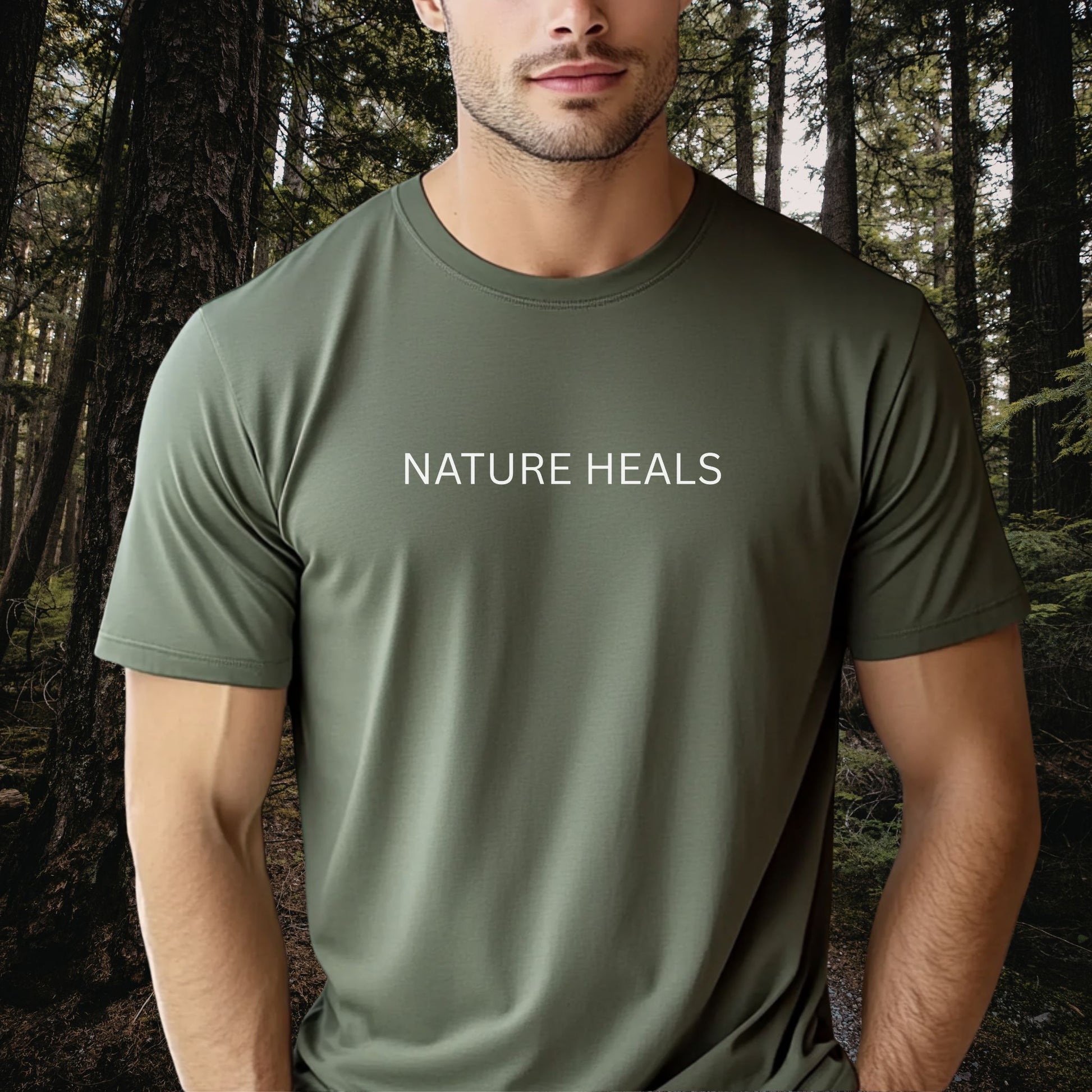 Man wearing a green t-shirt with 'NATURE HEALS' text in a forest setting