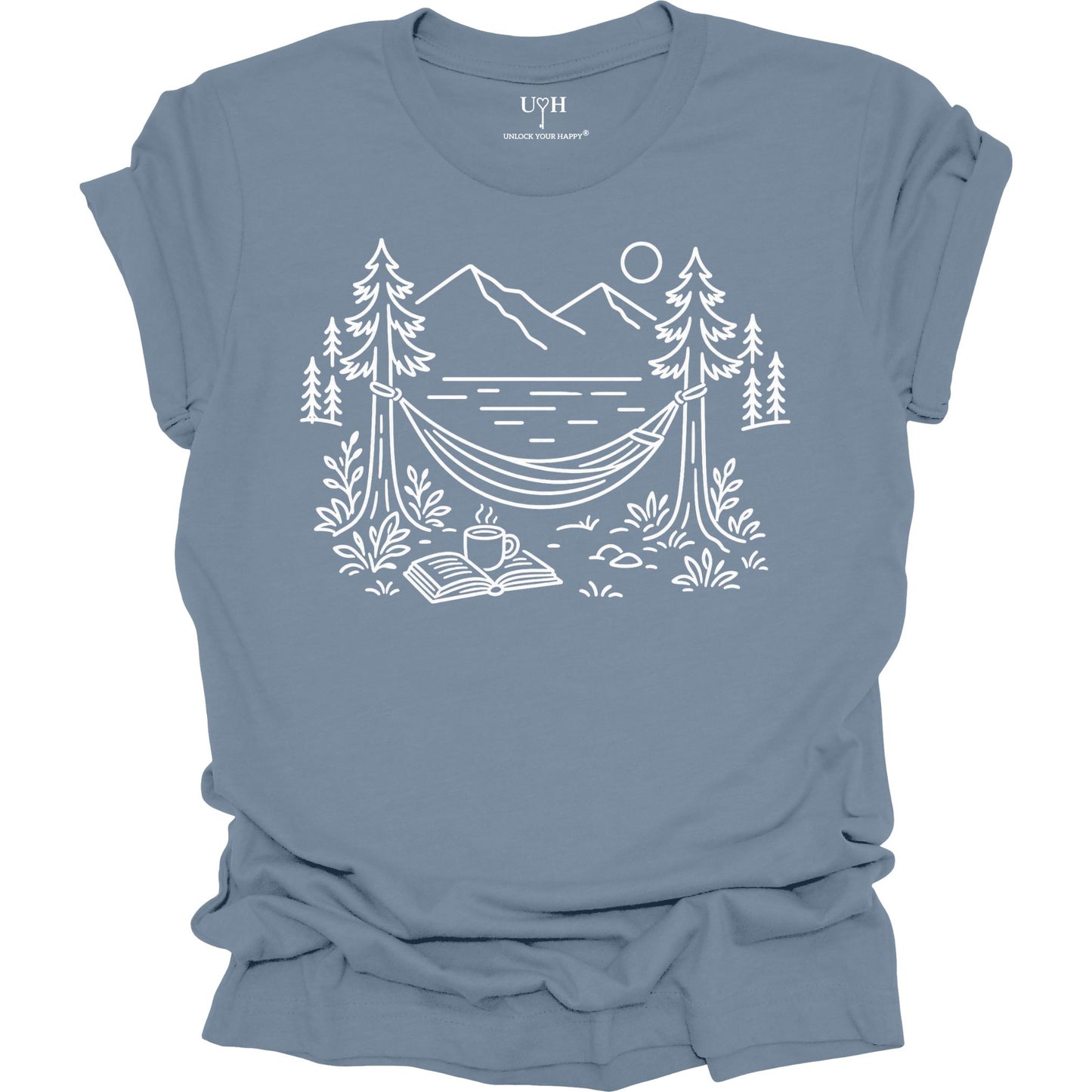 Blue unisex t-shirt with a white line art hammock scene featuring mountains, trees, a lake, coffee cup, and open book, plus ‘unlock your happy’ on the sleeve.