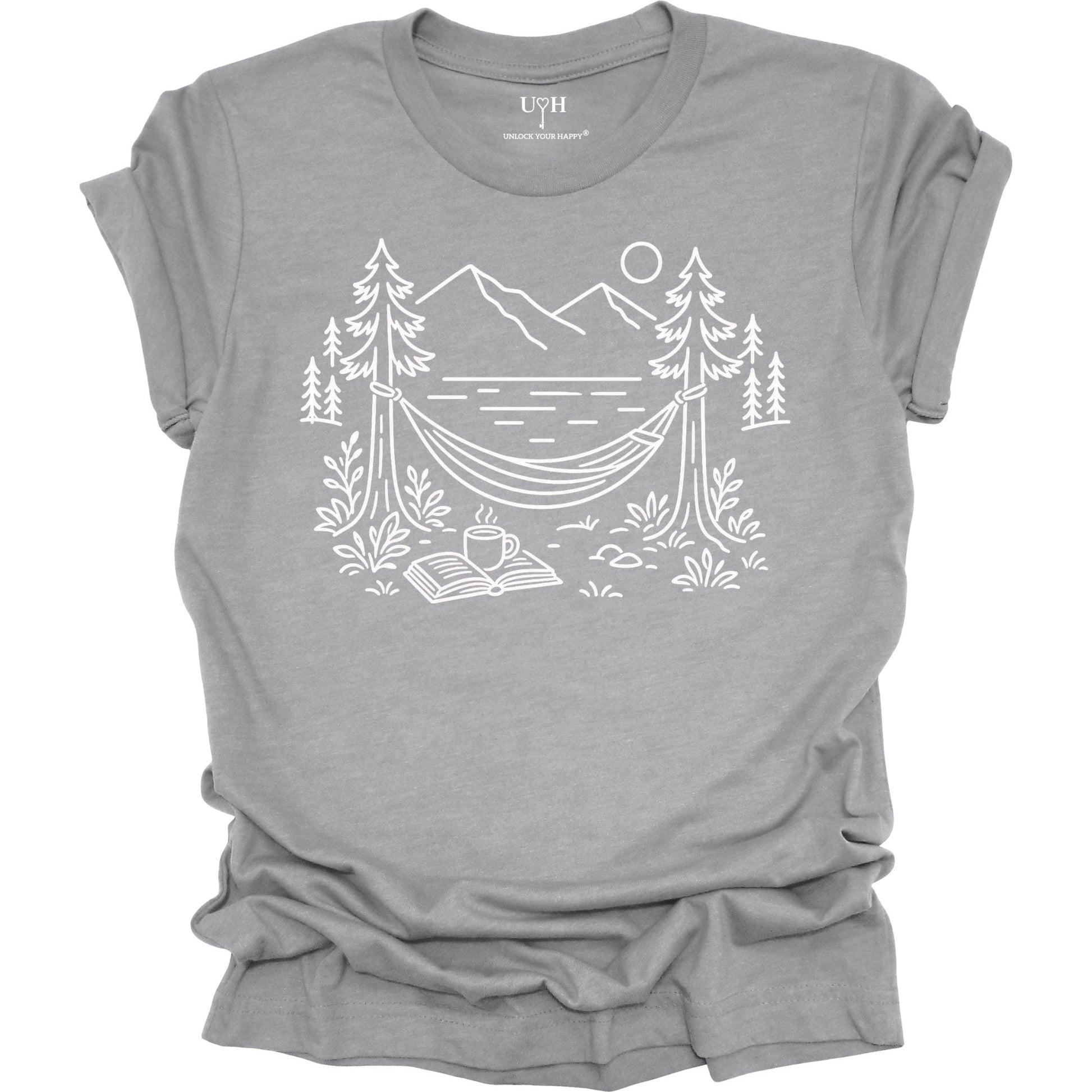 Gray unisex t-shirt with a white line art hammock scene featuring mountains, trees, a lake, coffee cup, and open book, plus ‘unlock your happy’ on the sleeve.