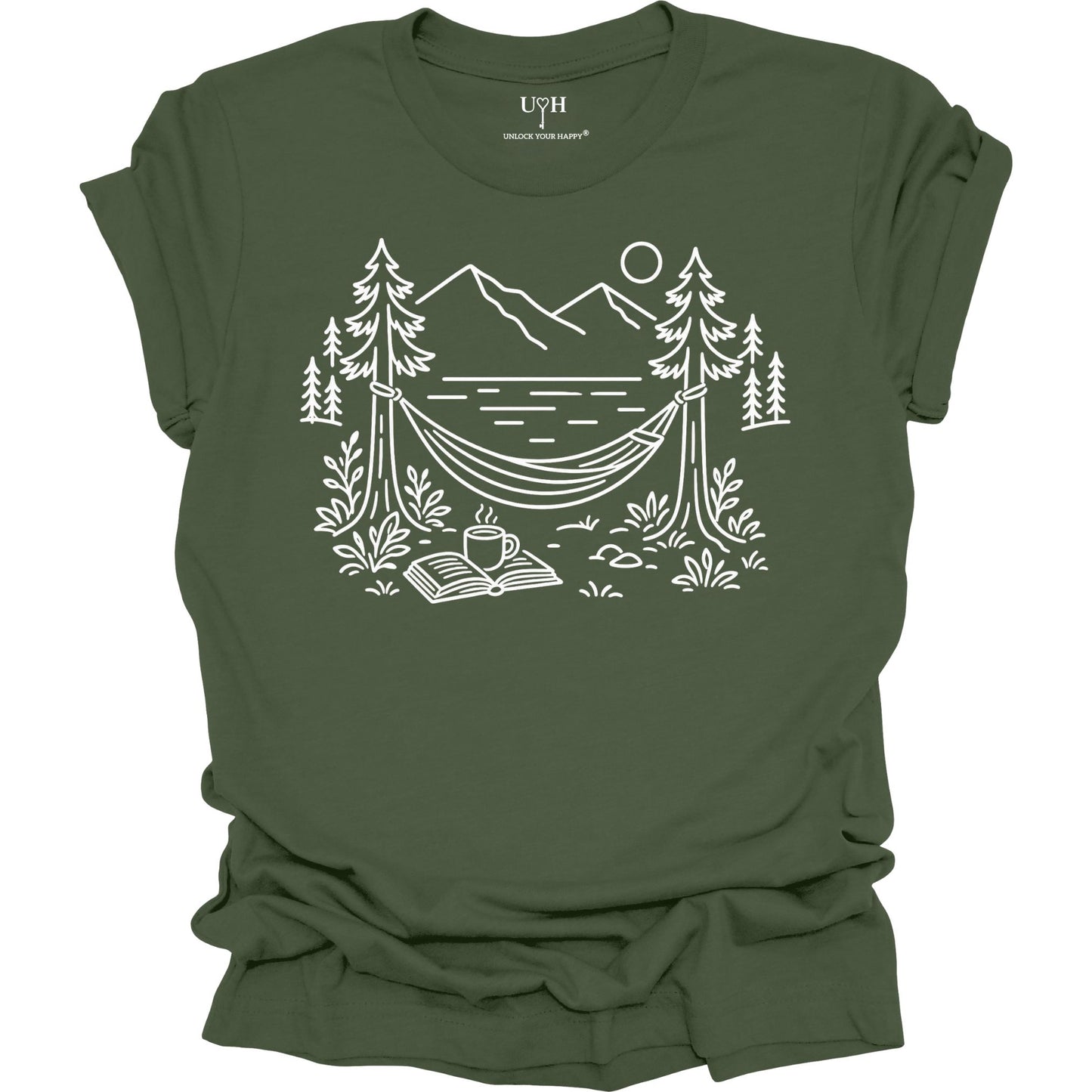 Green unisex t-shirt with a white line art hammock scene featuring mountains, trees, a lake, coffee cup, and open book, plus ‘unlock your happy’ on the sleeve.