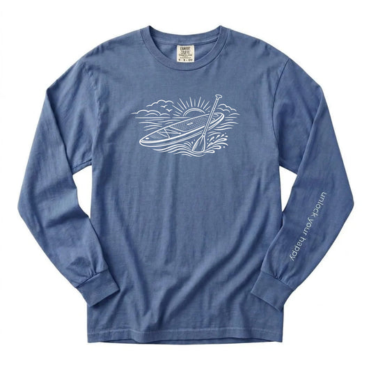Unlock Your Happy paddleboard long sleeve shirt featuring a white paddleboard and sunrise graphic on a blue jean colored Comfort Colors tee