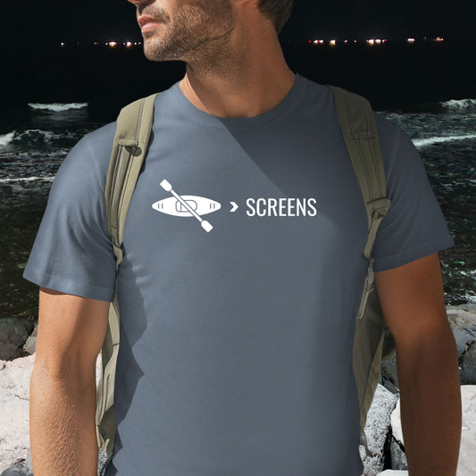 Man by water wearing a blue  t-shirt with Kayak graphic with over screens  text, digital detox nature shirt for outdoor lovers