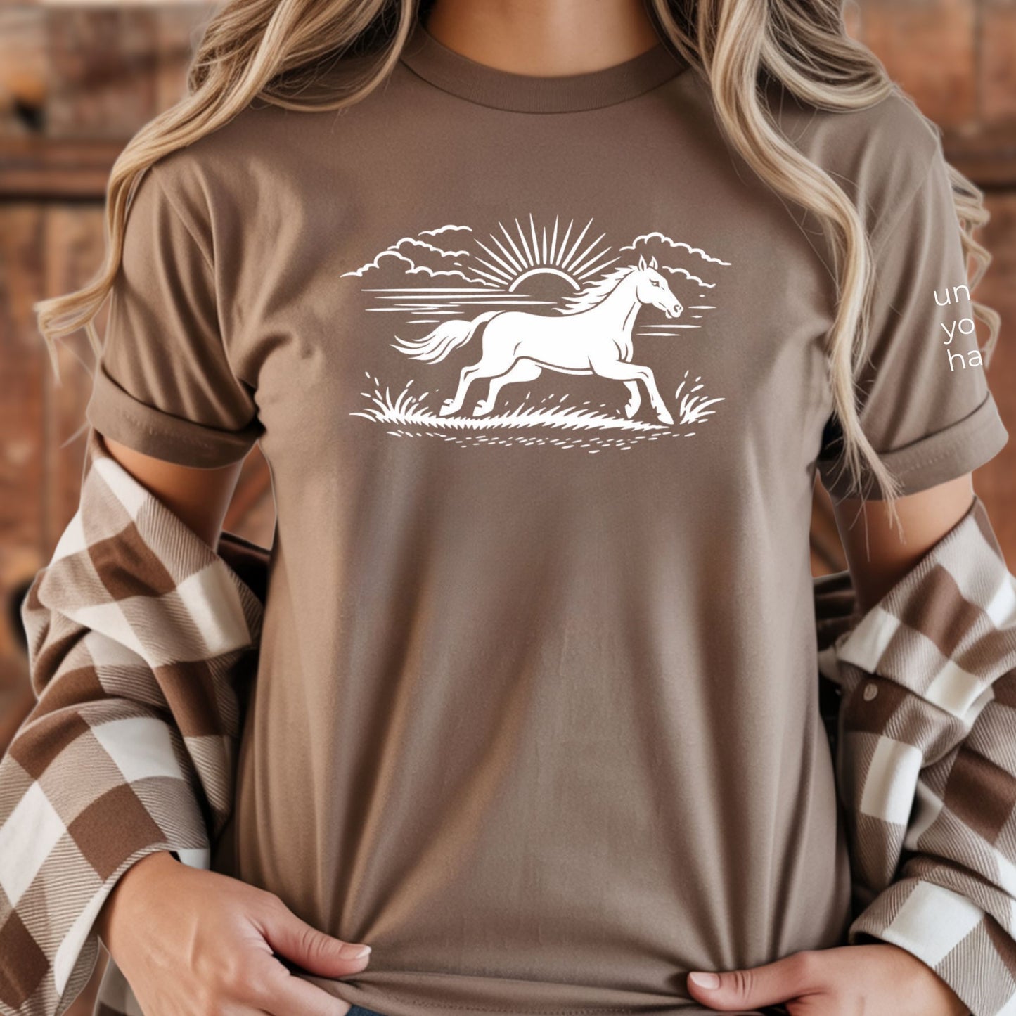 Person wearing a brown t-shirt with a white horse graphic design.