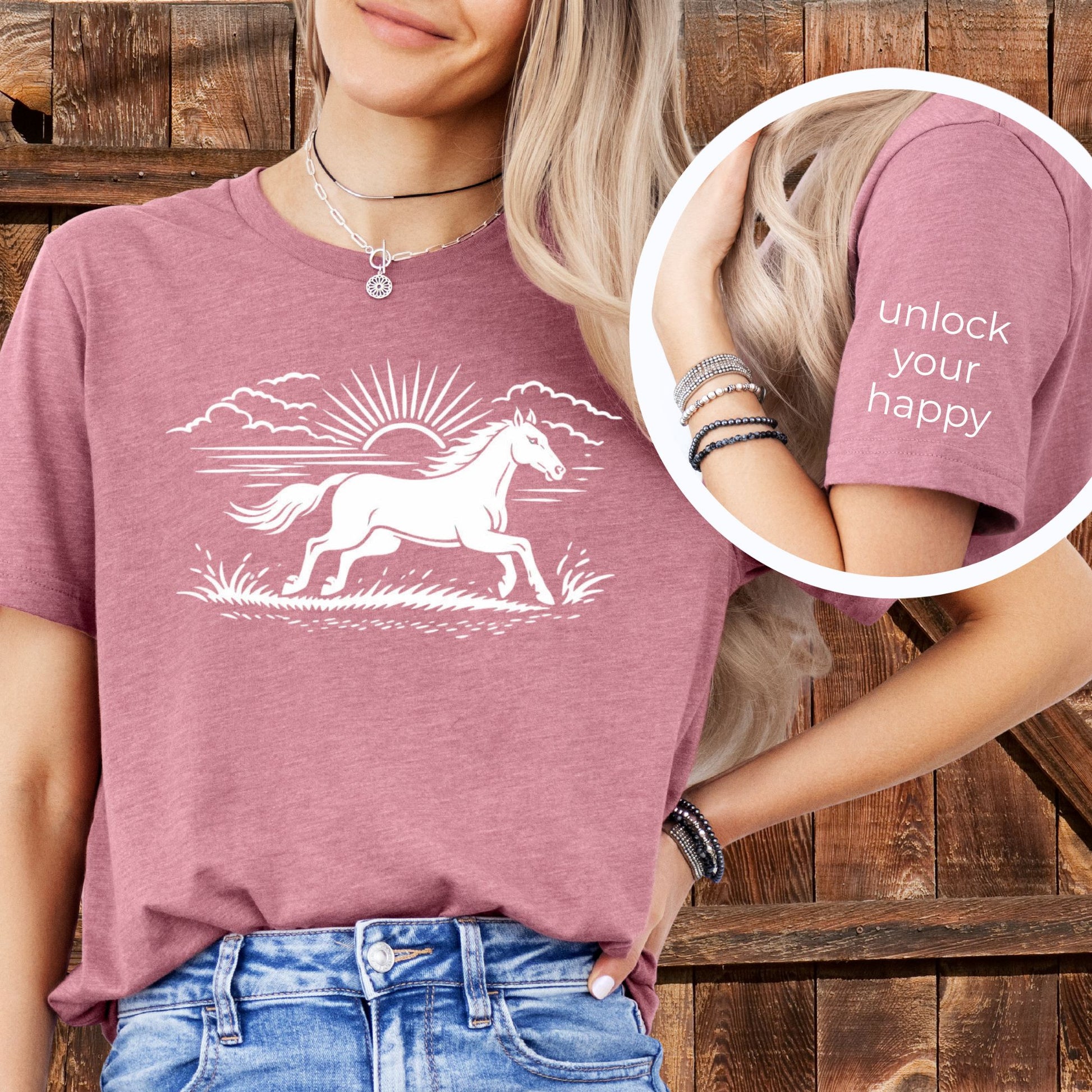 Person wearing a pink t-shirt with a horse graphic and text 'unlock your happy' on a wooden background
