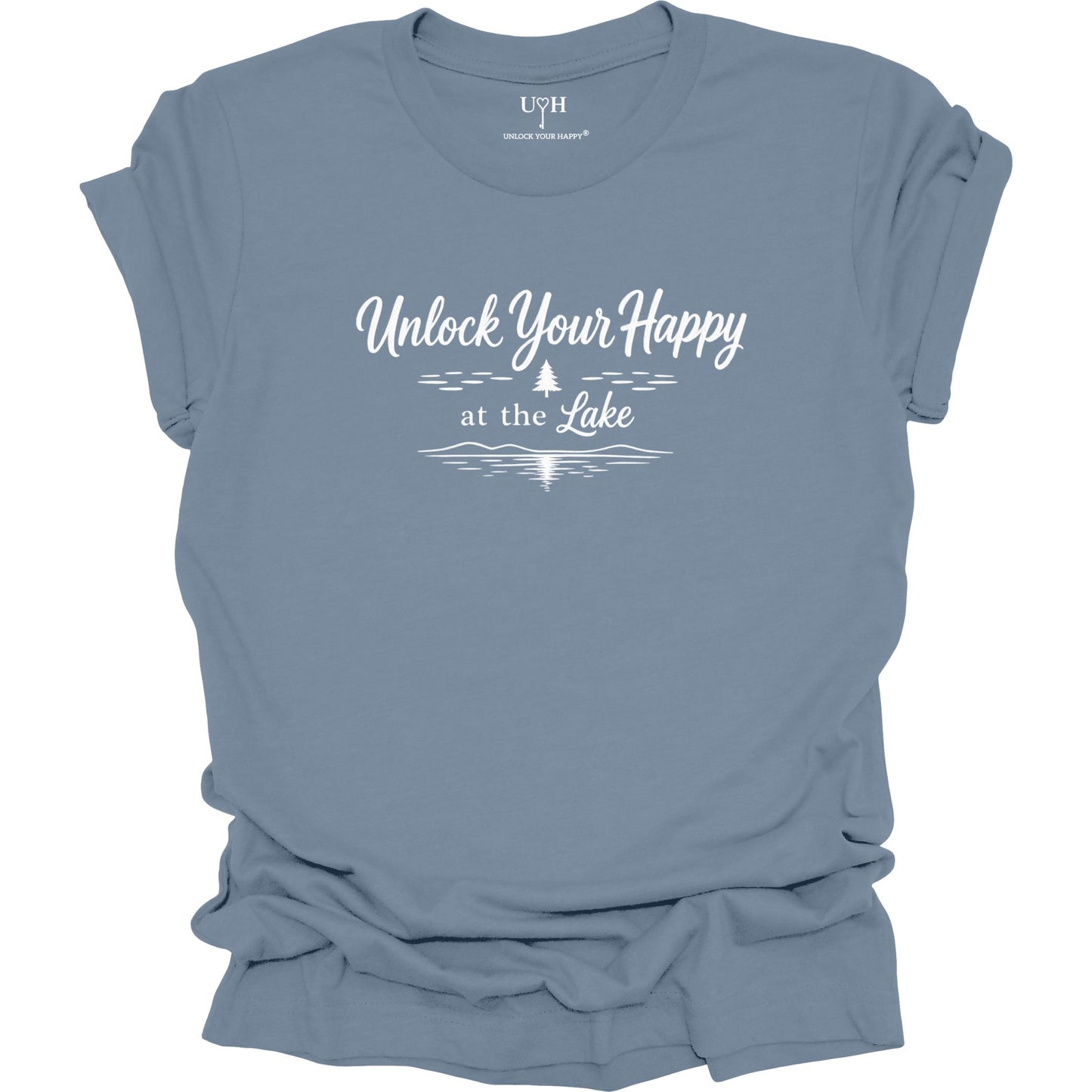 A blue short-sleeve t-shirt with a white graphic print that reads 'Unlock Your Happy at the Lake' above a simple pine tree and lake wave silhouette. The shirt is shown flat with a slightly rumpled drape, and the brand name 'UYH' is visible inside the collar.