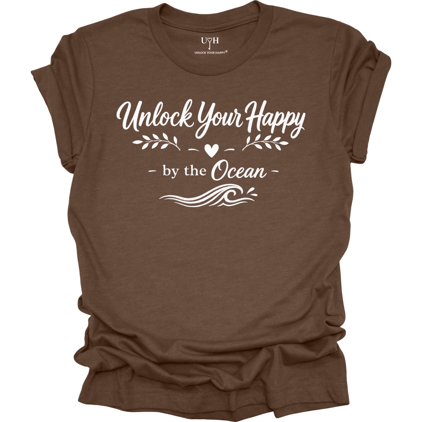 Brown t-shirt with white text 'Unlock Your Happy by the Ocean' on a white background