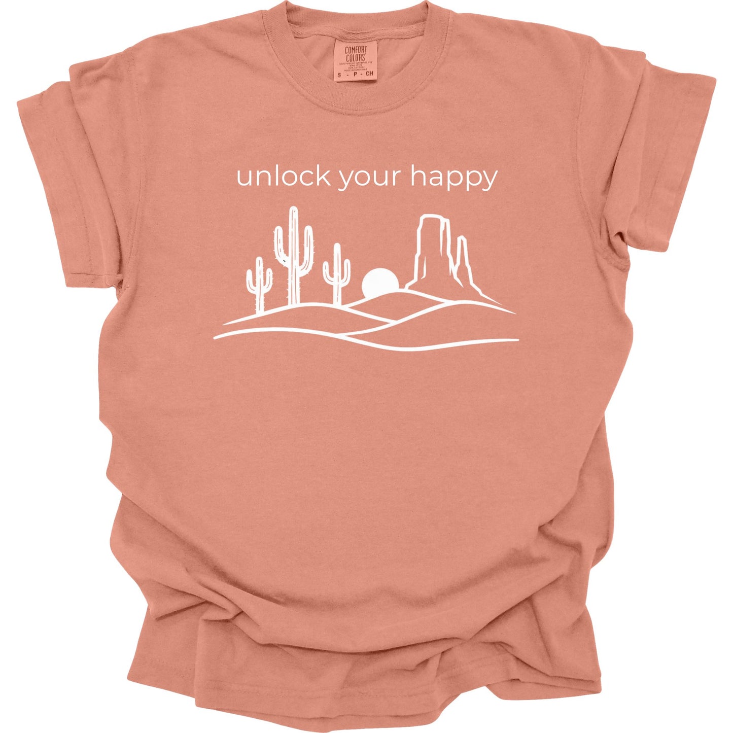 Terracotta colored  t-shirt with desert graphic and 'unlock your happy' text on a white background