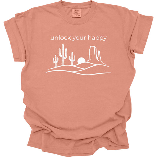 Terracotta colored  t-shirt with desert graphic and 'unlock your happy' text on a white background