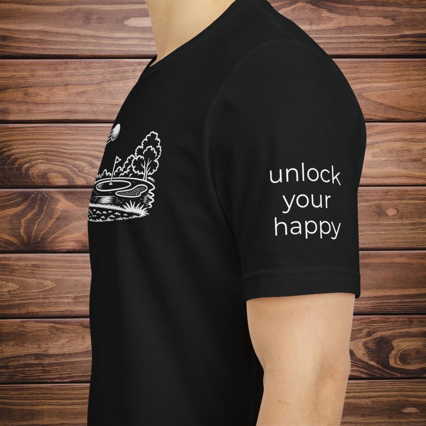 Black t-shirt with white graphic and text 'unlock your happy' on a wooden background